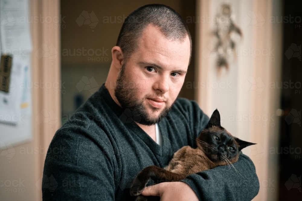 bearded-young-man-with-down-syndrome-holding-cat-austockphoto-000205472.jpg