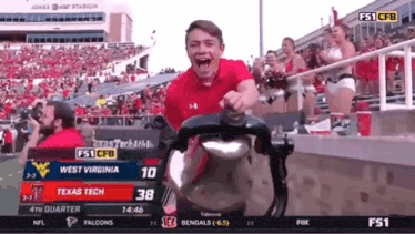 a man in a red shirt is riding a stroller in a stadium .