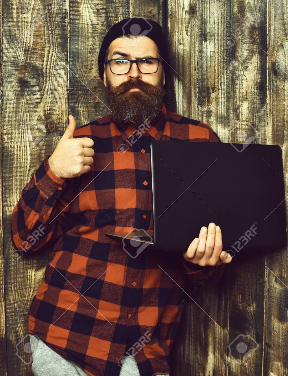 158374117-bearded-brutal-caucasian-hipster-holding-laptop.jpg